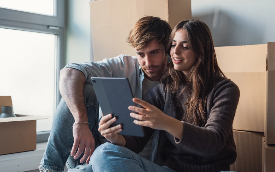 Diagnostiqueur immobilier équipé d'une caméra thermique infrarouge inspectant un mur intérieur d'une pièce du logement lors d'une visite de diagnostic énergétique, analysant les performances thermiques du bâtiment pour établir un DPE projeté.