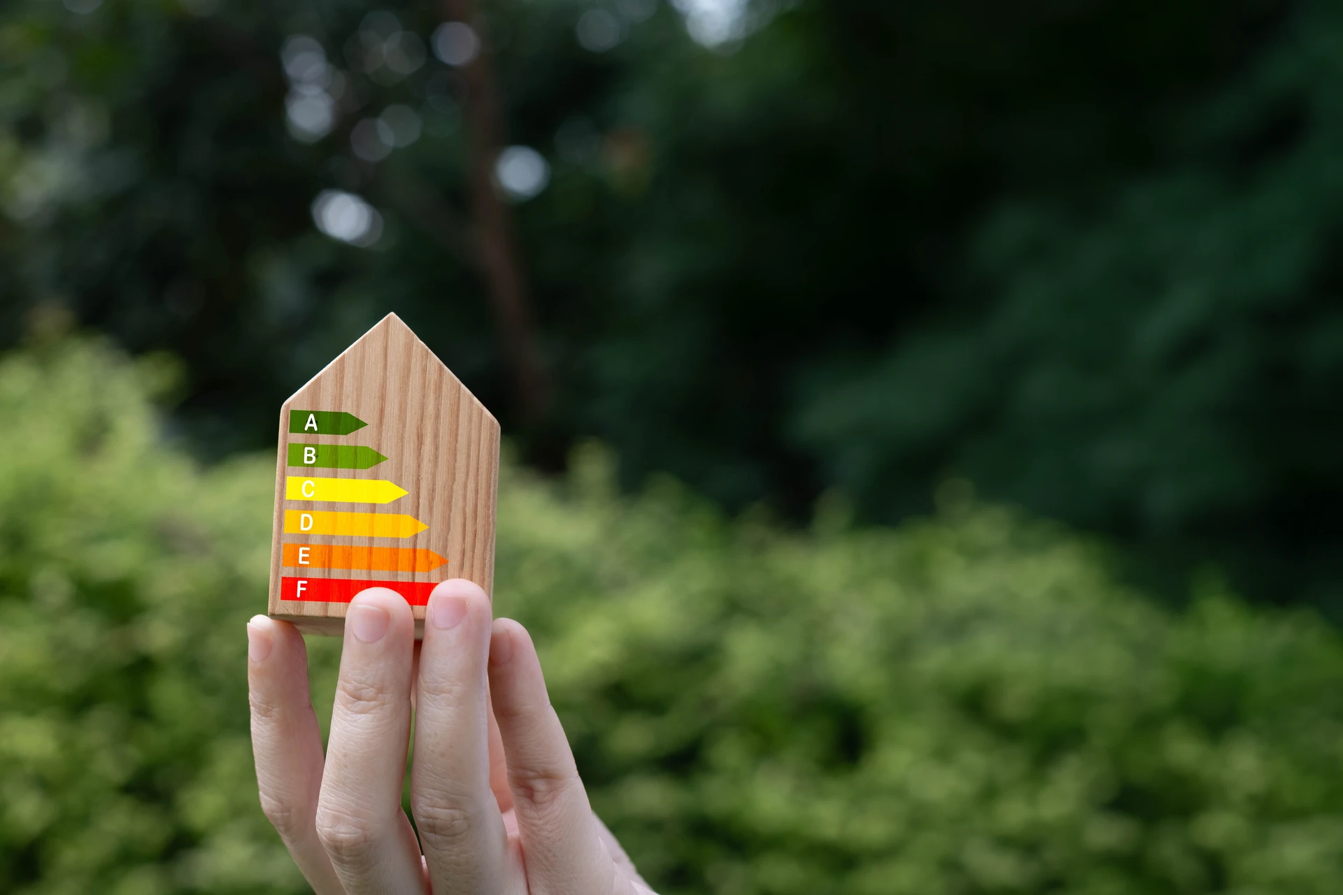 Diagnostiqueur immobilier effectuant un relevé thermique à l'intérieur d'un logement, utilisant une caméra thermique infrarouge pour mesurer la performance énergétique en vue d'un DPE projeté, dans un environnement résidentiel typique avec murs et fenêtres visibles.